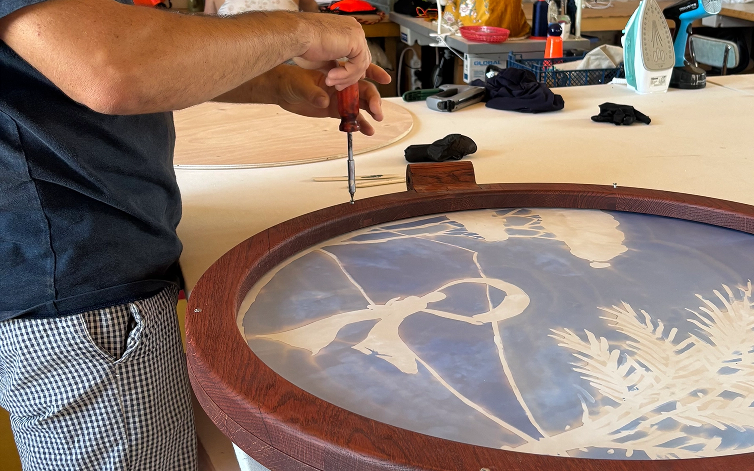 Un paravent élégant en chêne teinté, aux cercles rougeoyants évoquant le bois brûlé, rehaussé de pieds noirs et de boules en bois clair. Les panneaux de soie, peints à la main par l’artiste textile française Elo de la Rue du Can, capturent la délicatesse des camées antiques. Une pièce raffinée pour sublimer tout intérieur.
